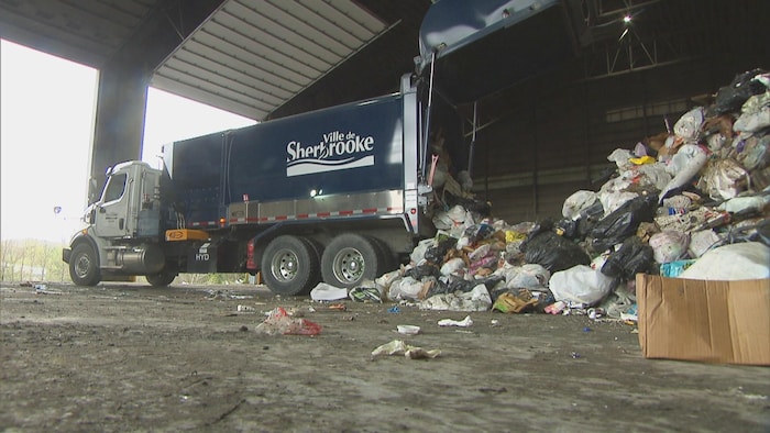 Un camion de déchet déverse son contenu dans un centre de tri.