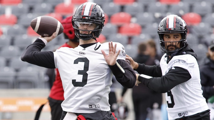 Deux joueurs s'apprêtent à lancer des ballons de football.
