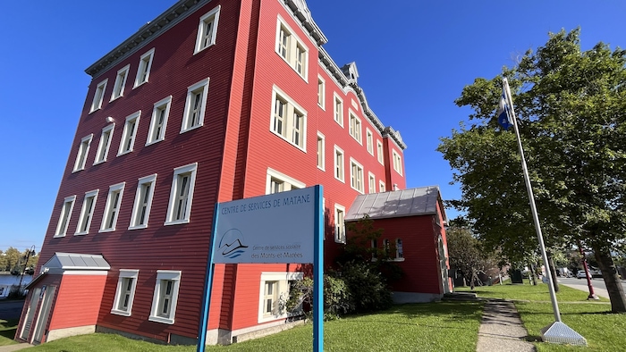 Un bâtiment rouge du centre de services scolaires des Monts-et-Marées à Matane, baigné de soleil.