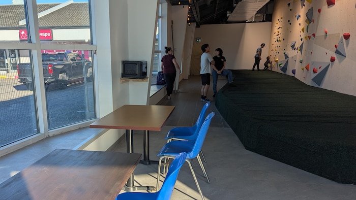 Des tables et des chaises dans un centre d'escalade intérieur.