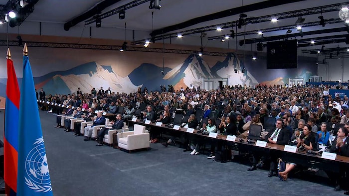 Des gens assis dans une salle de conférence.