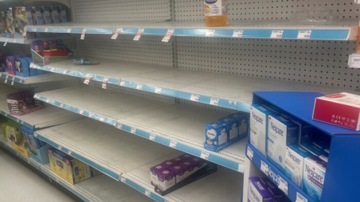 Des étalages vides dans un supermarché au rayon lait de bébé.