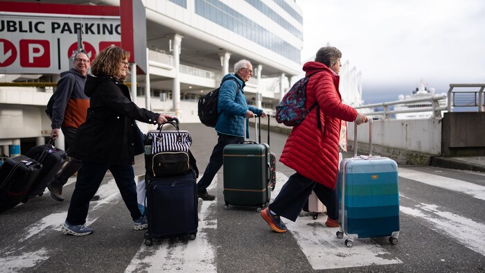 Des touristes du Disney Wonder, le premier navire de croisière à arriver au port de Vancouver, sont photographiés, le 26 février 2026.
