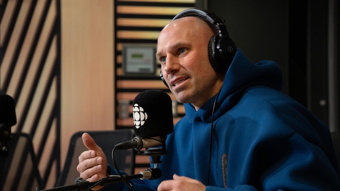 Un homme fait une entrevue dans un studio de radio.
