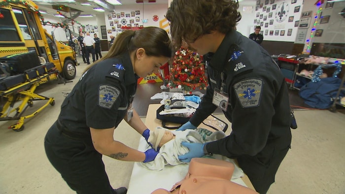 Les deux étudiants manipulent un bébé mannequin.