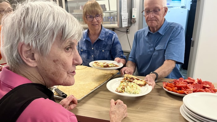 Des gens donnent des assiettes remplies de nourriture à une personne.