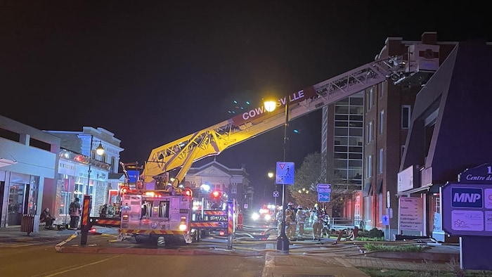 Les pompiers de Cowansville à l'oeuvre pour éteindre un feu dans un bâtiment commercial du centre-ville.