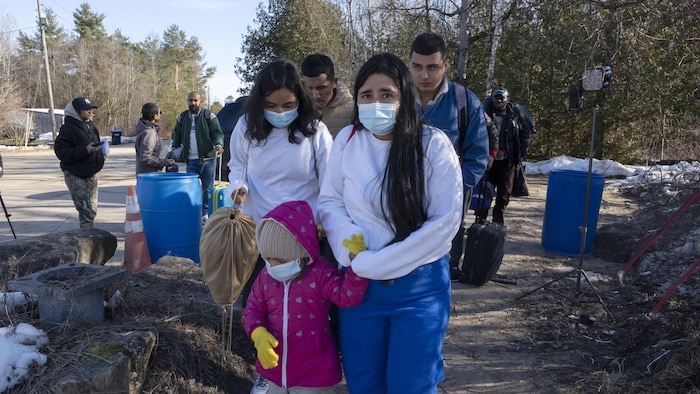 Une famille traverse la frontière à pied.