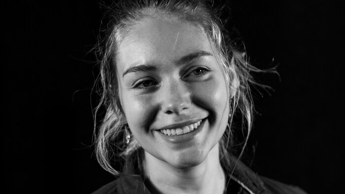 Un femme souriante qui pose.