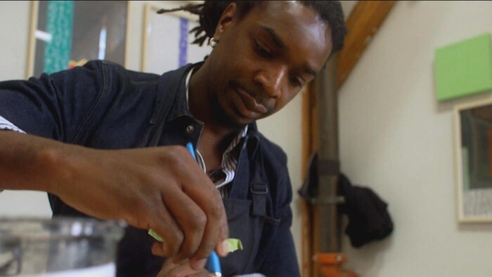 Le peintre Ghislain Brown-Kossi au travail.
