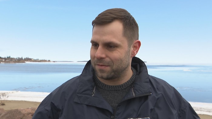 Homme avec un manteau de l'agence d'inspection des aliments près de la mer