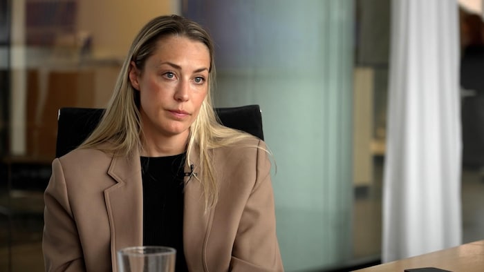Une femme est assise dans une salle de conférence.