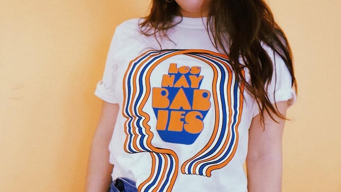 Un des t-shirts des Hay Babies, qui fait penser à l'esthétique des années 1960 avec ses grosses lettres et lad ruban bicolore