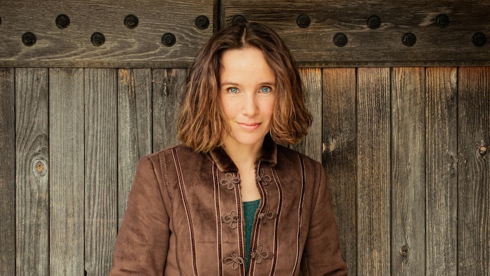 Hélène Grimaud devant un mur de bois.