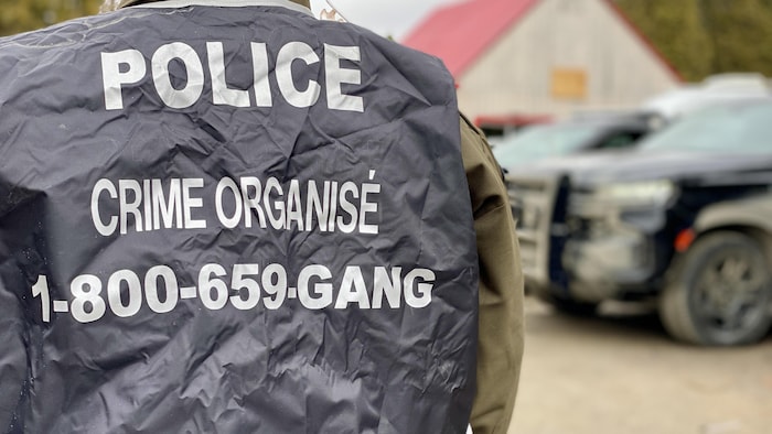 Un policier de dos avec un dossard. 