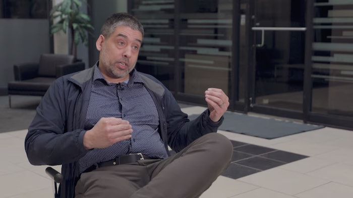 Jason Hosain est assis et prêt à répondre aux questions des journalistes
