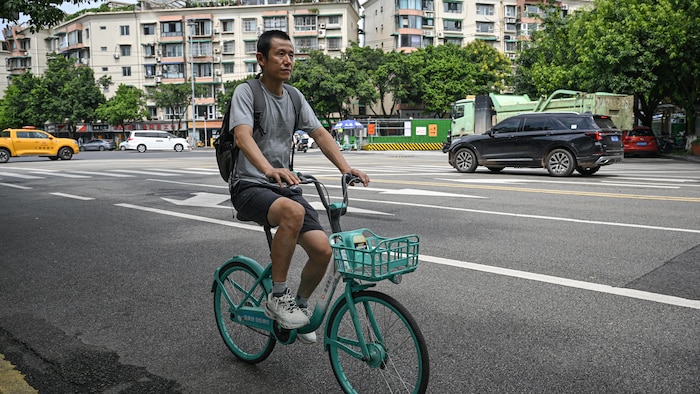 Un homme sur une bicyclette dans une rue.