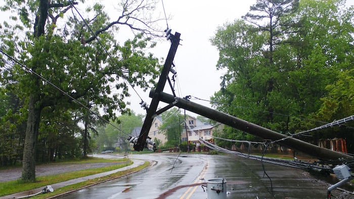 Un poteau électrique endommagé dans une rue.