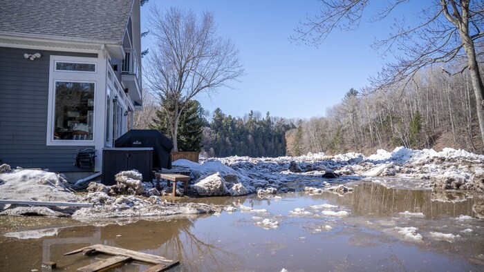 Une rivière sortie de son lit, une résidence et de la glace.
