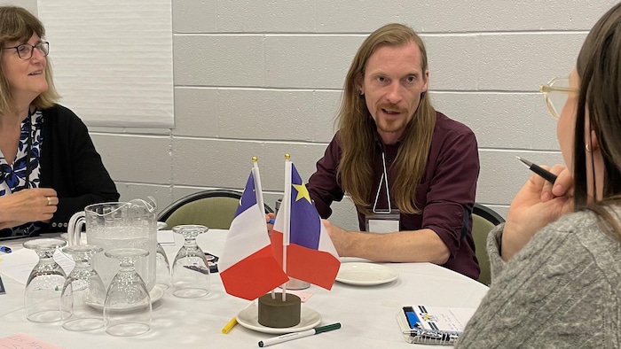 Des personnes discutant autour d'une table ronde.