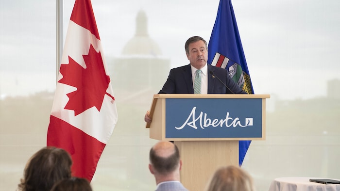 Jason Kenney talks with the podium of Canada and Alberta Flags on June 17, 2022.