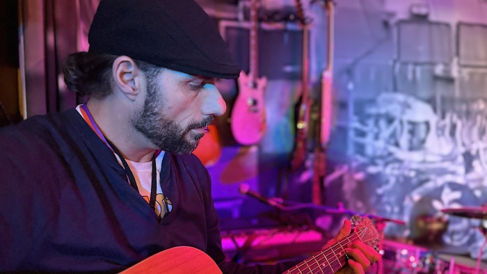 Jeepy joue de la guitare dans un studio.
