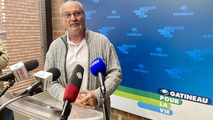 Un homme parle devant des micros