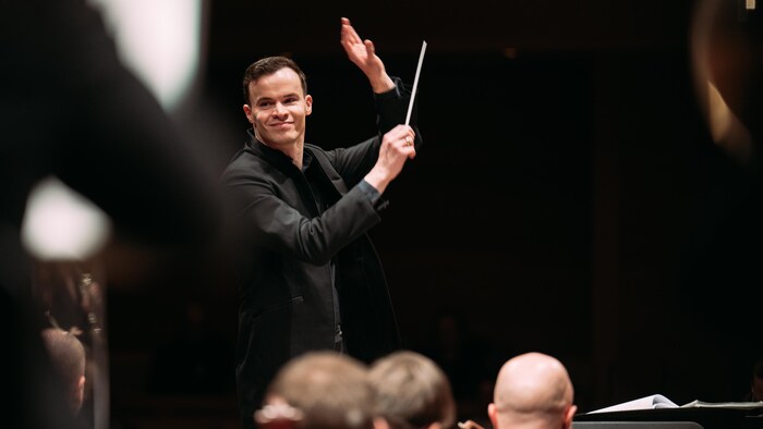 Un chef d'orchestre en performance lors d'un spectacle.