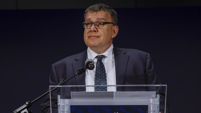 Jon McKenzie tient un lutrin marqué Global Energy Show à Calgary le 9 juin. 