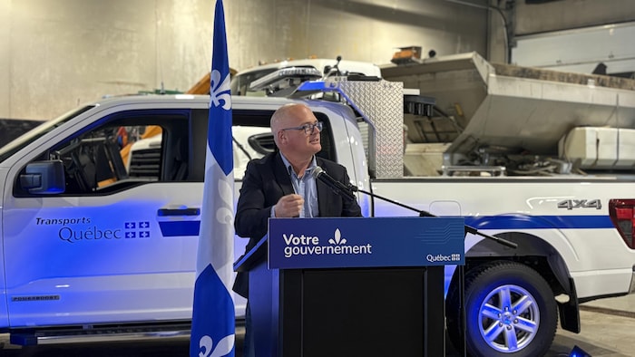 Un homme qui parle devant un lutrin.