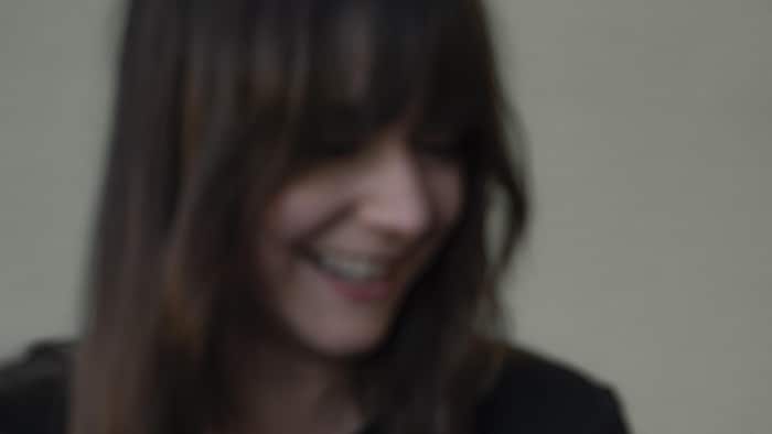 Une femme souriante qui regarde vers le bas.
