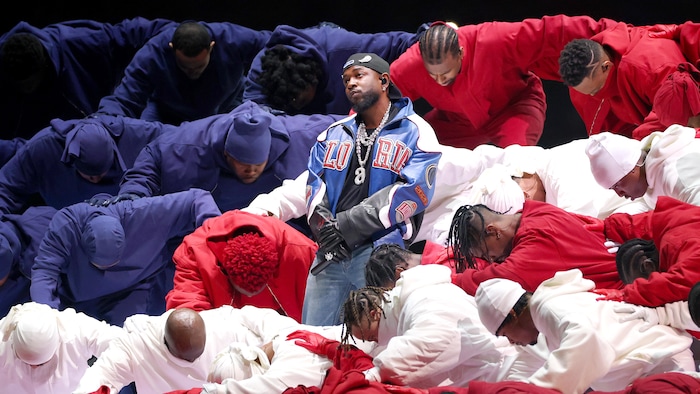 Kendrick Lamar et des danseurs sur une scène.