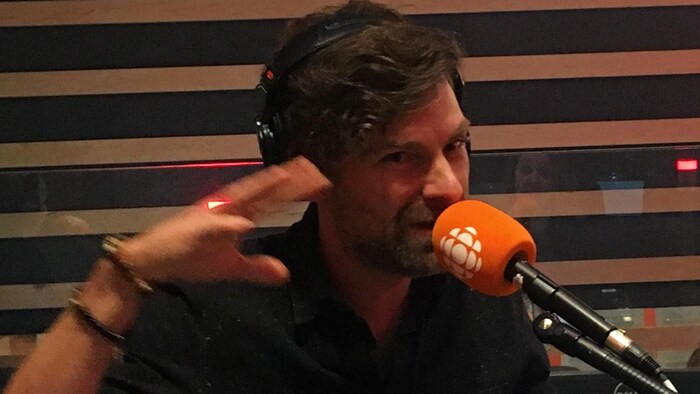 Un homme parle dans un studio de radio.