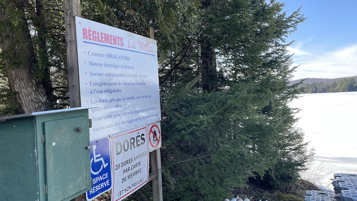 Le lac Moffat et sur sa rive, une liste des règlements entourant la pêche. 