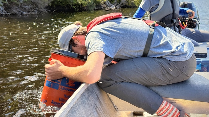 Une personne utilise un aquascope sur une chaloupe.