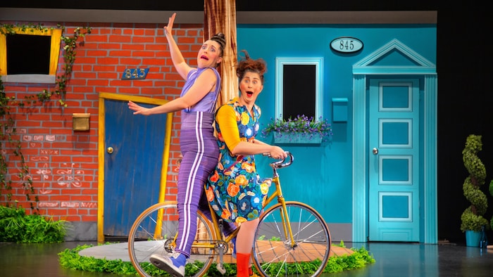 Deux femmes sur une bicyclette dans la pièce «Les voisines».