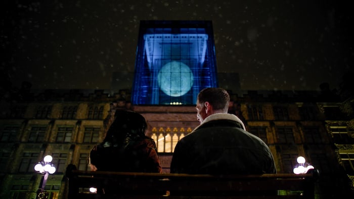 Une femme et un homme assis sur un banc devant le Musée canadien de la nature.