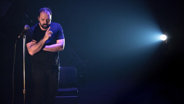 Un homme debout derrière un micro.