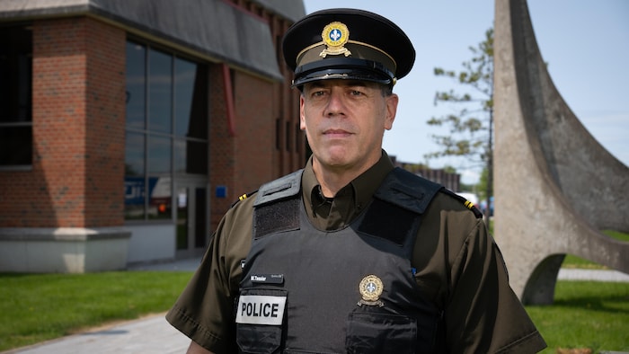 Un policier pose devant le quartier général de la Sûreté du Québec.