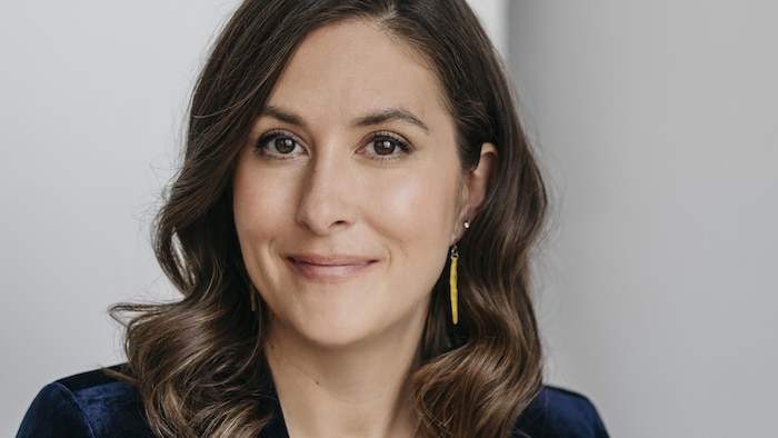 Une femme souriante qui pose.