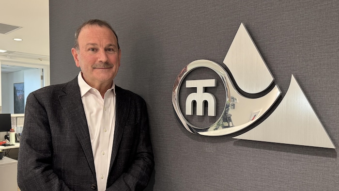 After a year, did the promises fill the mountain tubes? star-news.press/wp Mark Maki is bent behind a wall next to the Logo of Trans Mountain Company.