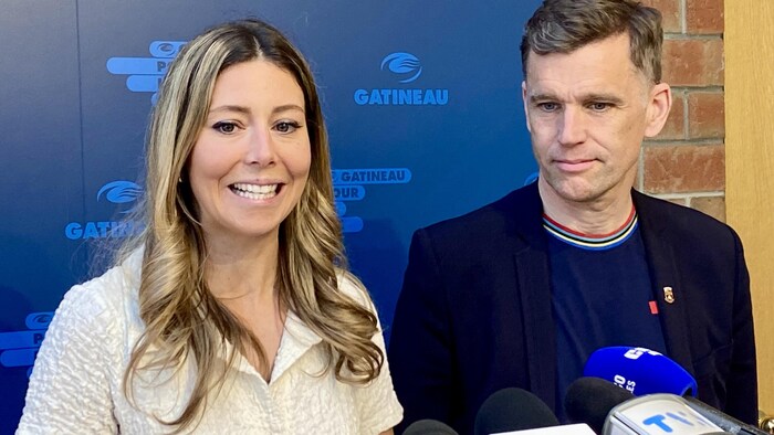 Deux politiciens parlent devant des micros.