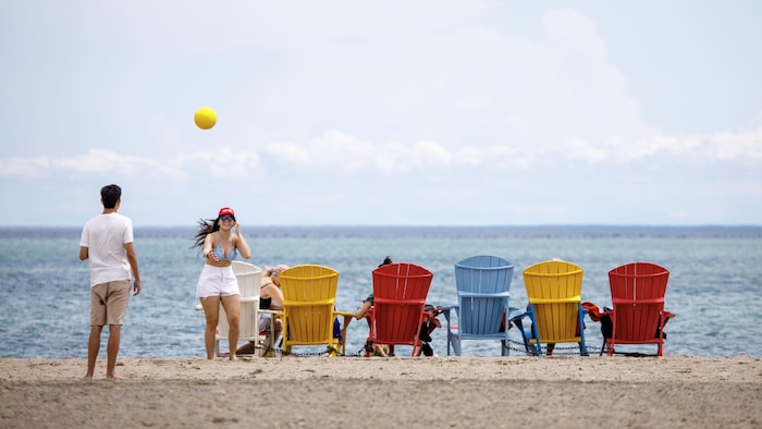 Des personnes sont photographiées sur la plage Woodbine à Toronto, le 13 juillet 2023.