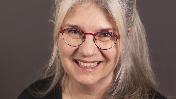 Un femme souriante qui pose.