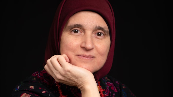 Un femme souriante qui pose.