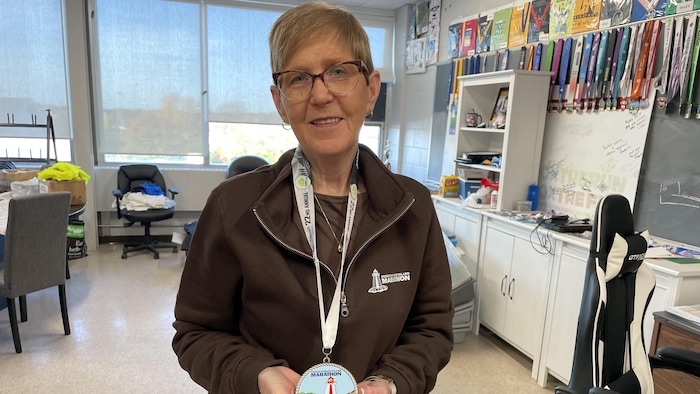 Myrtle Smith-Jenkins qui tient une médaille de la 22e édition du demi-marathon de l'Île-du-Prince-Édouard