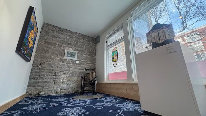 Une salle comportant une oeuvre d'art et une chaise berçante.