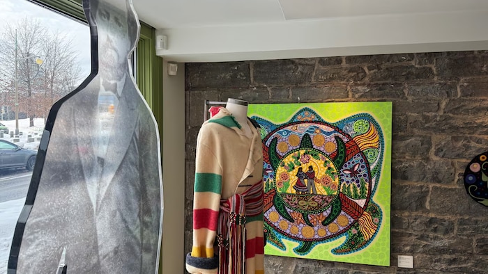 L'intérieur d'un magasin métis avec un manteau et une oeuvre d'art.