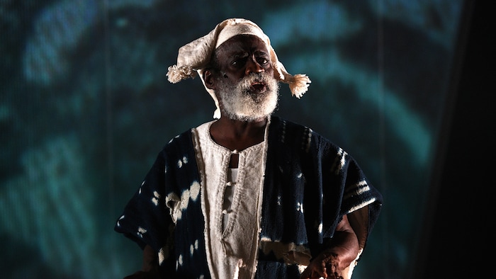 Un homme costumé sur une scène.
