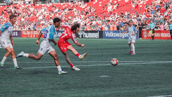 Un joueur de soccer tire dans un ballon. 